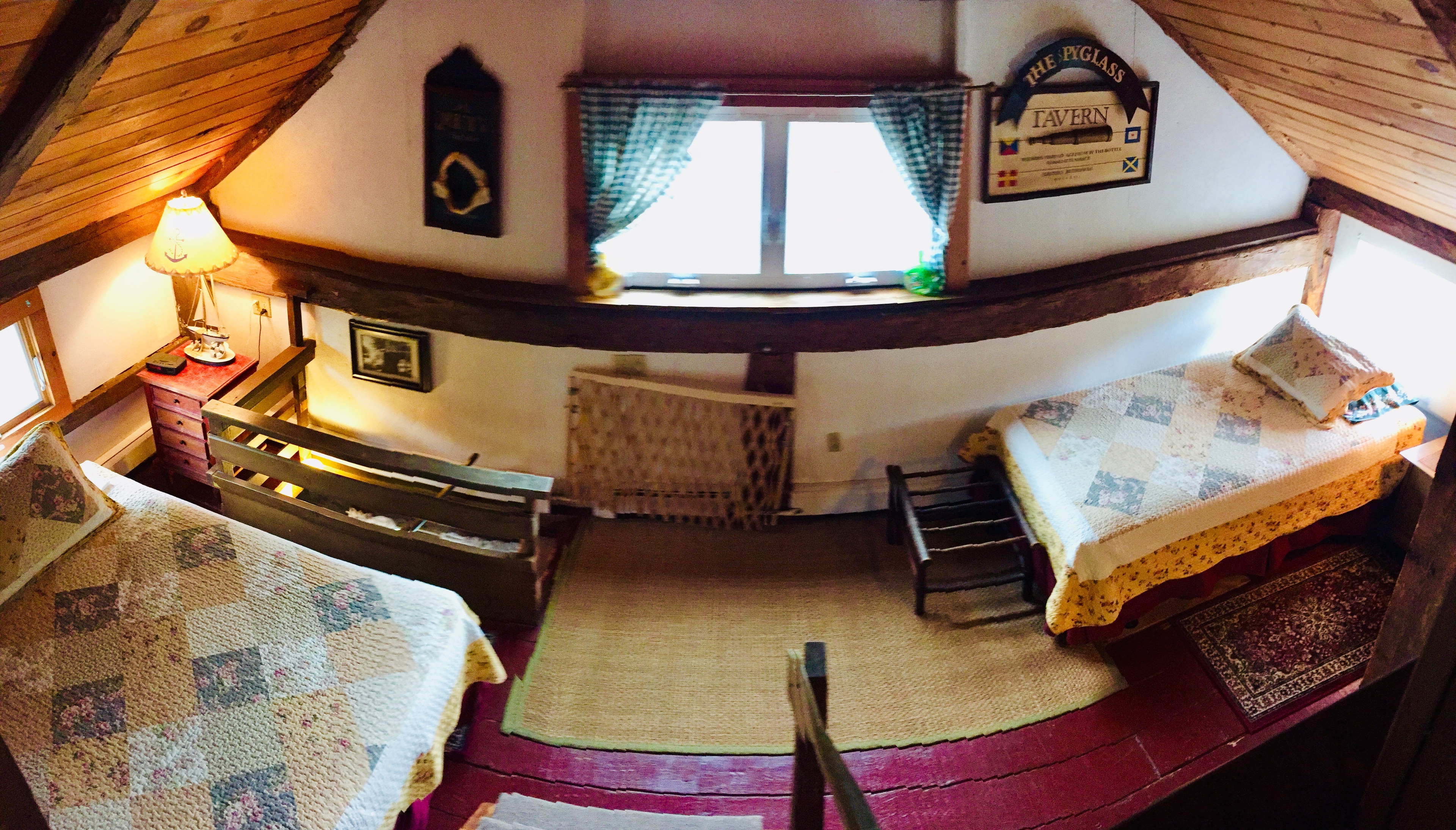 A photo of the largest Barn loft with a queen bed and a twin. Both have quilt blankets.