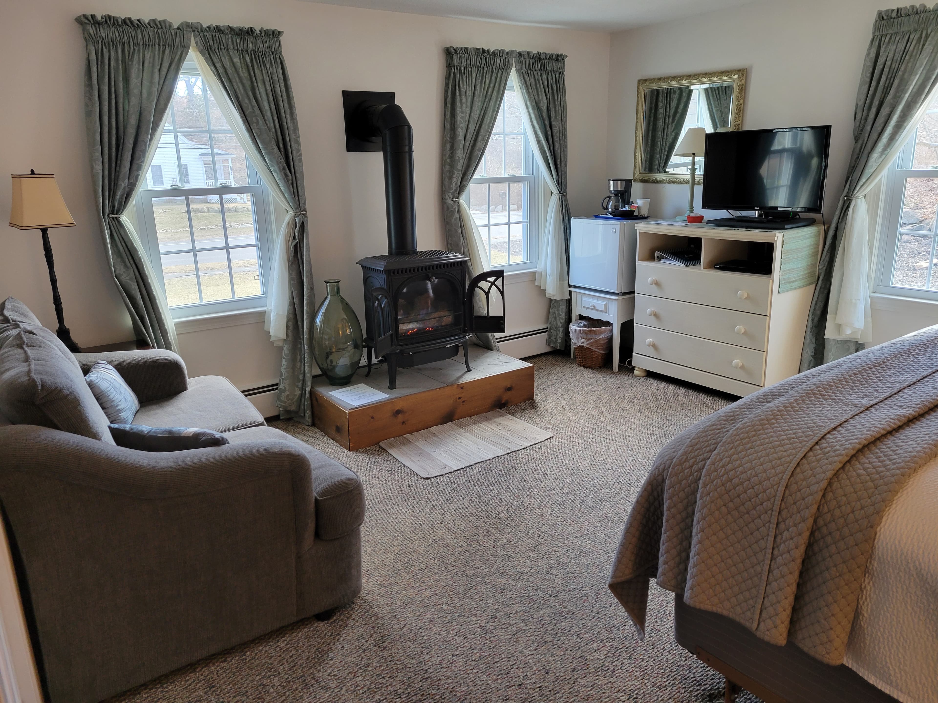 Photo of room of blue and grays. Bedside lamp is on.