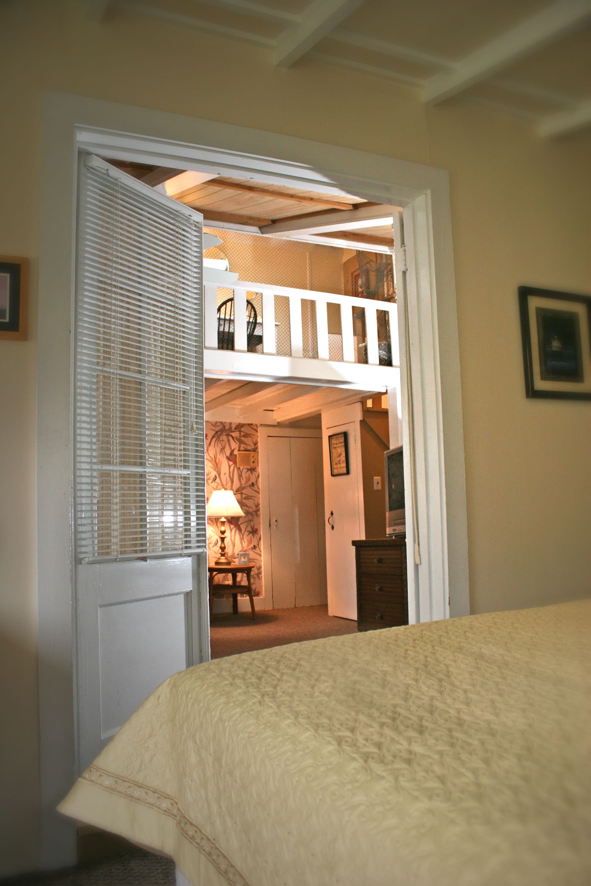 A photo from the master bedroom looking into the living room with a white loft in the distance