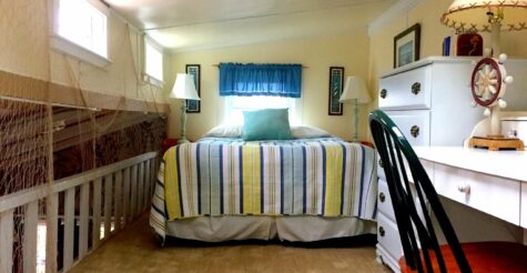 The loft bed and bedroom with striped blanket