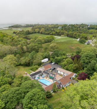 Aerial view of the inn with trees and water in the background